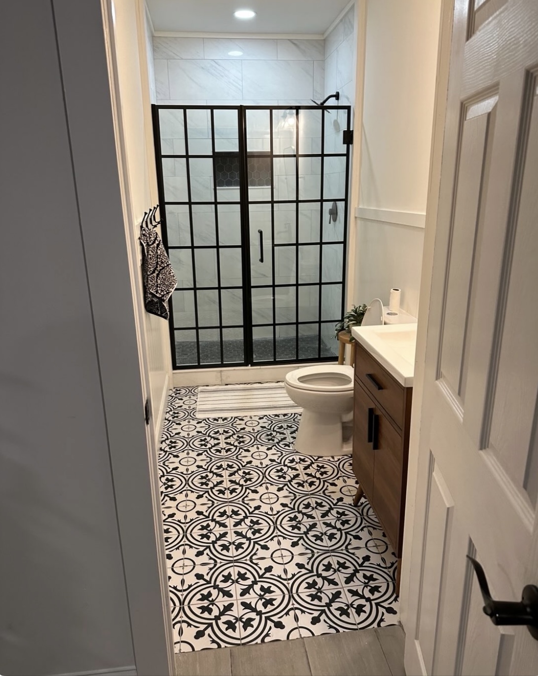 Custom basement bathroom with patterned tile and glass shower